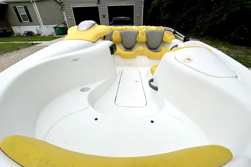 Slide: The Image of 2004 Sea-Doo Sportster LE DI boat interior with yellow and gray seating, parked outdoors. - 4