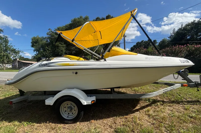 Slide: The Image of 2004 Sea-Doo Sportster LE DI boat with yellow canopy on trailer, parked outdoors. - 1