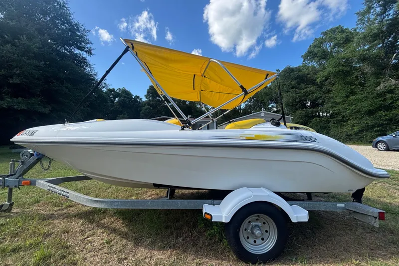 Slide: The Image of 2004 Sea-Doo Sportster LE DI boat with yellow canopy on trailer, parked outdoors. - 7
