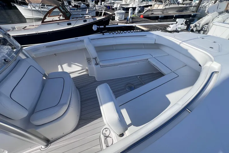 Slide: The Image of 2020 Southport 33 FE boat interior with white seating and sleek design at a marina. - 38