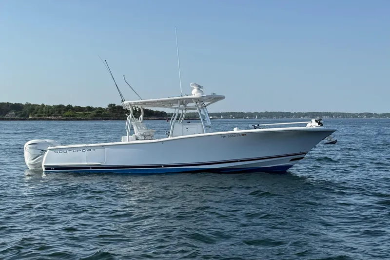Slide: The Image of 2020 Southport 33 FE boat on calm water, showcasing sleek design and twin engines. - 6