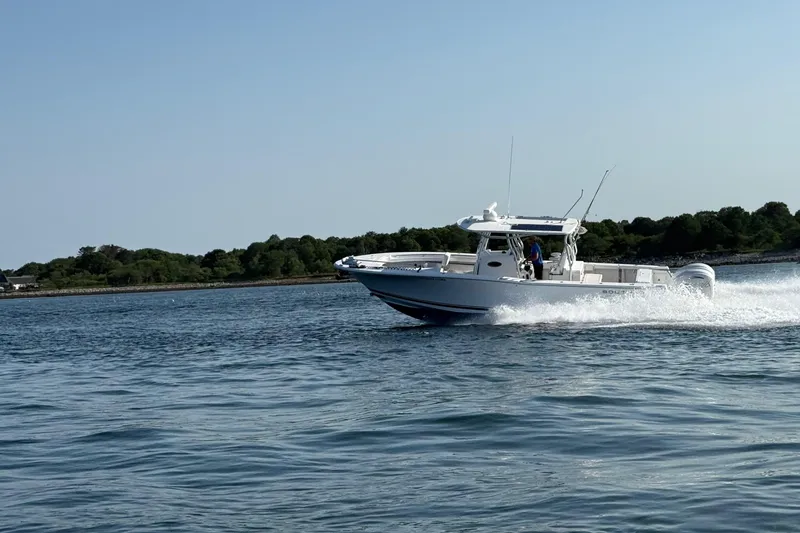 Slide: The Image of 2020 Southport 33 FE boat cruising on open water near a wooded shoreline. - 17