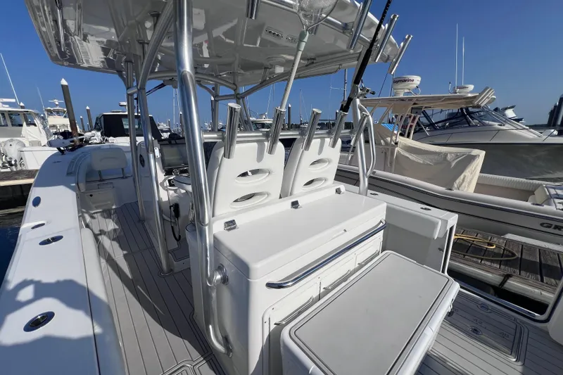 Slide: The Image of 2020 Southport 33 FE boat interior with seating and fishing rod holders at a marina. - 27