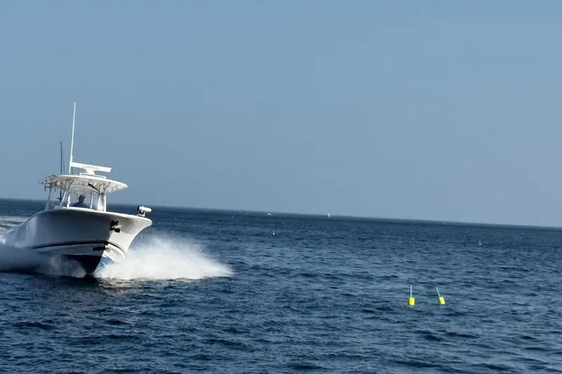 Slide: The Image of 2020 Southport 33 FE boat cruising on open water, creating a splash. - 19