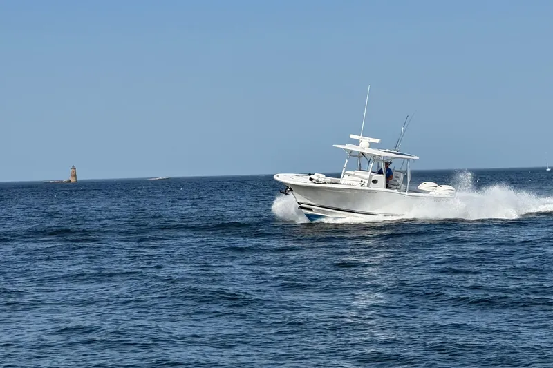 Slide: The Image of 2020 Southport 33 FE boat cruising on open sea near a distant lighthouse. - 12
