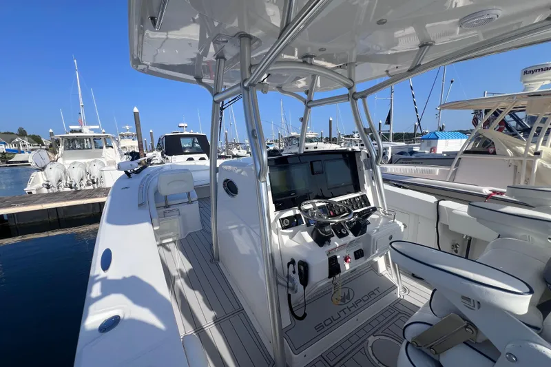 Slide: The Image of 2020 Southport 33 FE boat interior at marina, featuring helm and seating. - 30