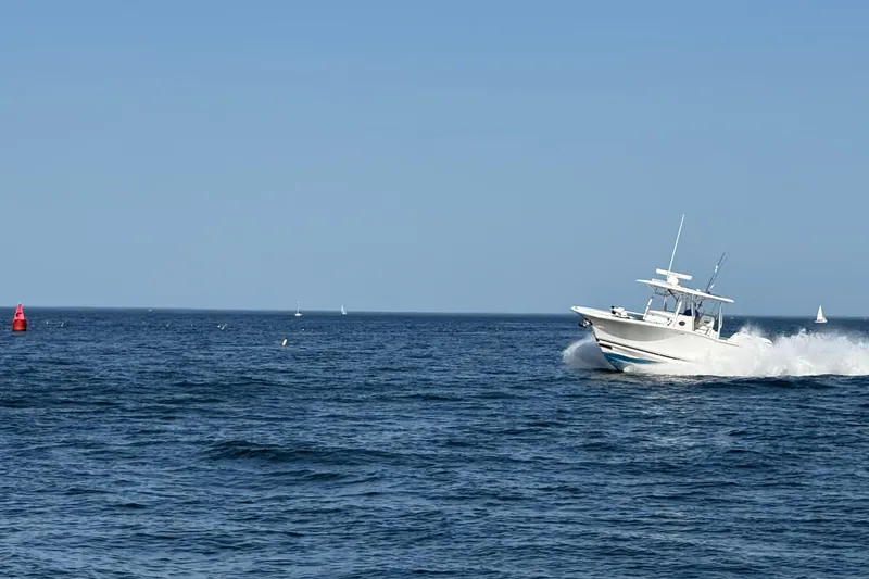 Slide: The Image of 2020 Southport 33 FE boat cruising on open sea under clear blue sky. - 10