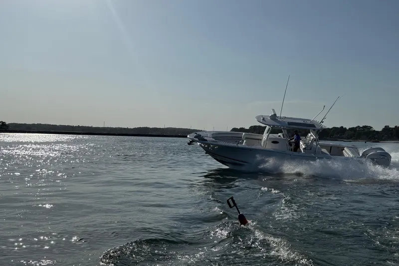 Slide: The Image of 2020 Southport 33 FE boat cruising on a sunny day, creating waves in open water. - 14