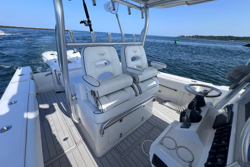 Slide: The Image of 2020 Southport 33 FE boat interior with helm and seating, cruising on open water. - 24