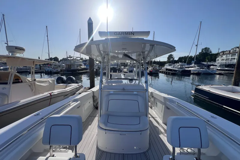 Slide: The Image of 2020 Southport 33 FE boat docked in a sunny marina with surrounding yachts. - 35