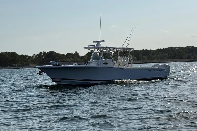 Slide: The Image of 2020 Southport 33 FE boat cruising on a calm lake with trees in the background. - 1