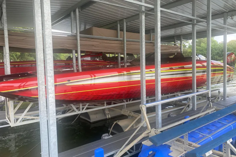 Slide: The Image of Red 2021 Doug Wright P360 boat docked in a covered marina. - 12