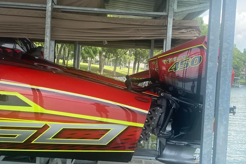 Slide: The Image of Red Doug Wright P360 boat with Racing 450 engine, docked under a metal shelter. - 11