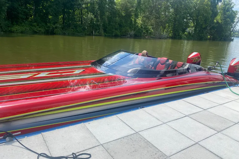 The Image of Red Doug Wright P360 powerboat docked on a calm river, 2021 model. - 2