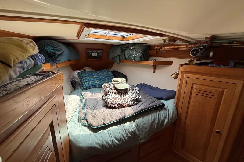 Slide: The Image of Cozy cabin interior of 1993 Tartan 4600 sailboat with bedding and storage. - 31