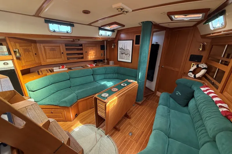 Slide: The Image of Luxurious 1993 Tartan 4600 yacht interior with teal seating and wooden cabinetry. - 38
