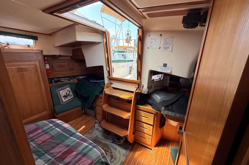 Slide: The Image of Cozy interior of a 1993 Tartan 4600 sailboat with wooden furnishings and natural light. - 17