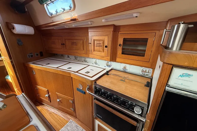 Slide: The Image of Wooden galley interior of 1993 Tartan 4600 yacht with stove and storage cabinets. - 29