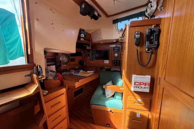 Slide: The Image of Cozy 1993 Tartan 4600 yacht interior with navigation station and wooden cabinetry. - 22