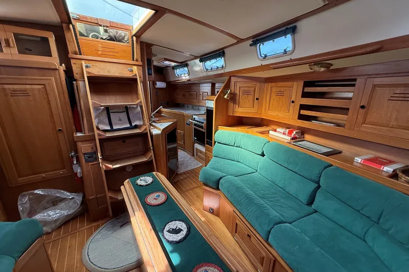 Slide: The Image of Interior of a 1993 Tartan 4600 yacht with wooden cabinetry and green seating. - 41