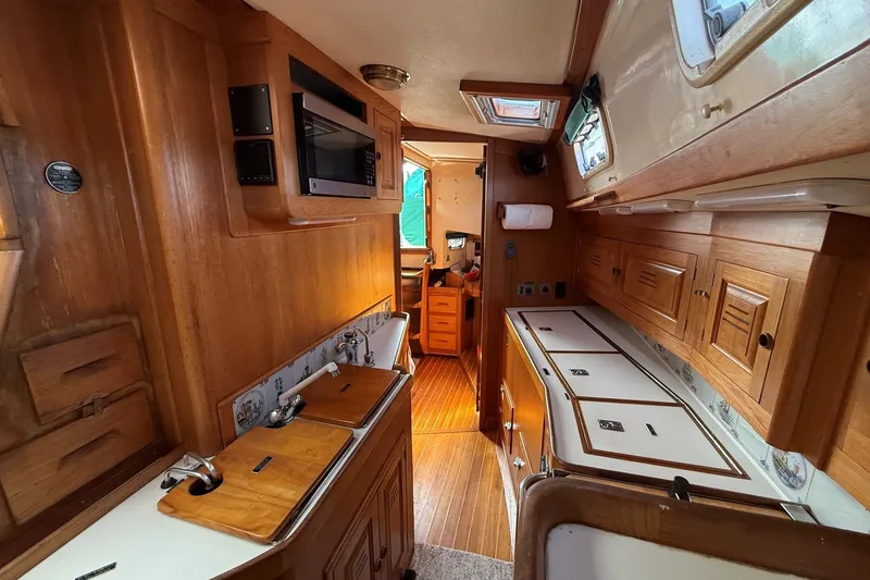 Slide: The Image of Interior of a 1993 Tartan 4600 sailboat with wooden cabinetry and modern amenities. - 28