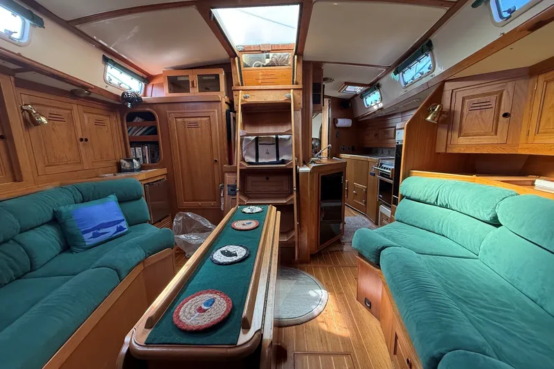 Slide: The Image of Interior of a 1993 Tartan 4600 yacht with green seating and wooden cabinetry. - 42