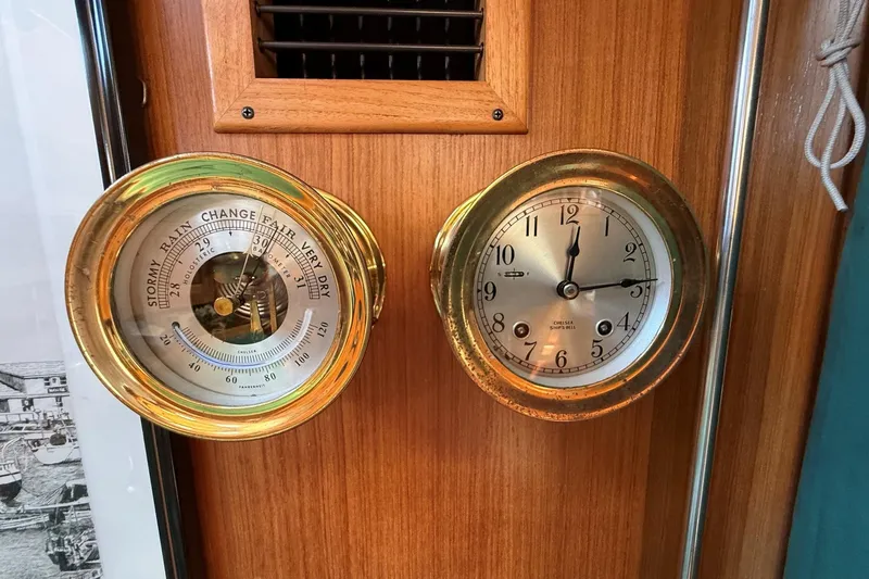 Slide: The Image of Brass barometer and clock on 1993 Tartan 4600 yacht's wooden interior. - 25