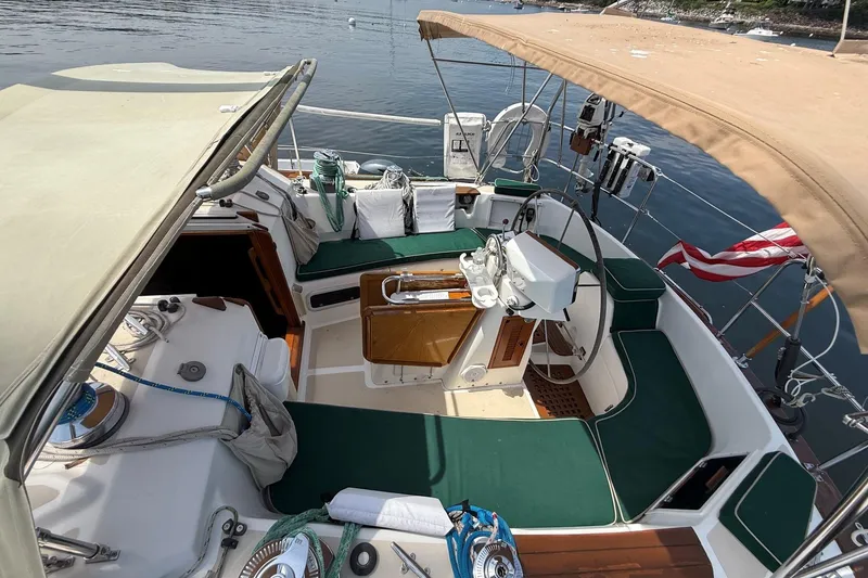 Slide: The Image of Cockpit of a 1993 Tartan 4600 sailboat with green cushions and nautical equipment. - 11