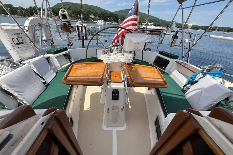Slide: The Image of Cockpit of 1993 Tartan 4600 sailboat with wooden table and American flag. - 12