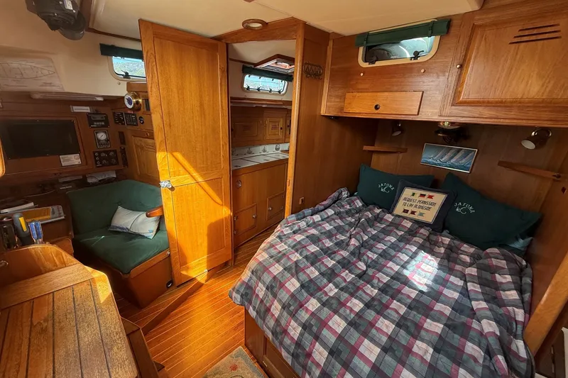 Slide: The Image of Cozy 1993 Tartan 4600 yacht cabin with wood interior and plaid bedding. - 17
