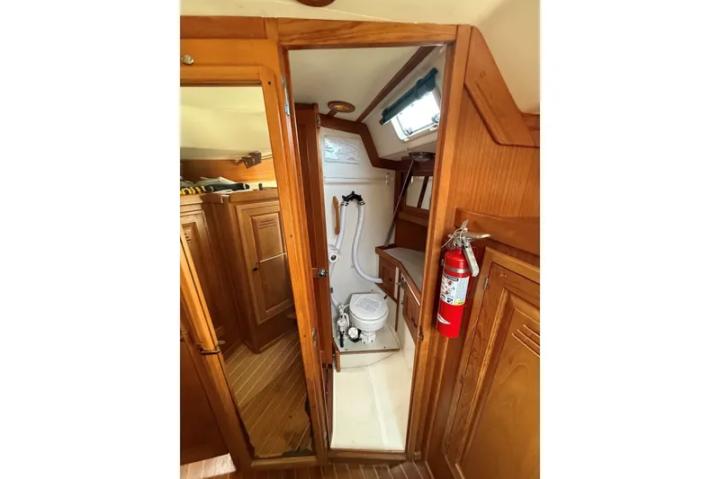 Slide: The Image of Interior of 1993 Tartan 4600 sailboat featuring wooden cabinetry and compact bathroom. - 44