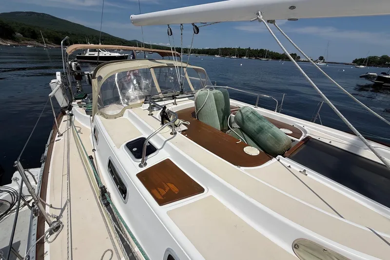 Slide: The Image of Sailboat Tartan 4600 from 1993 docked in a scenic harbor setting. - 6