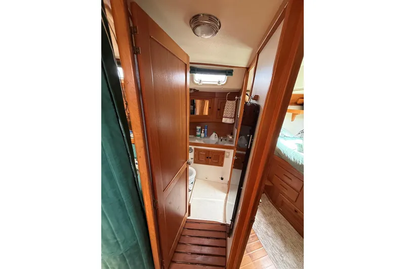 Slide: The Image of Interior of 1993 Tartan 4600 sailboat showing wooden cabinetry and compact bathroom. - 30