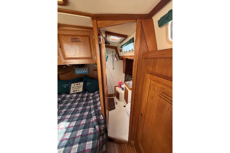 Slide: The Image of Cozy 1993 Tartan 4600 yacht interior with wood paneling and plaid bedding. - 24