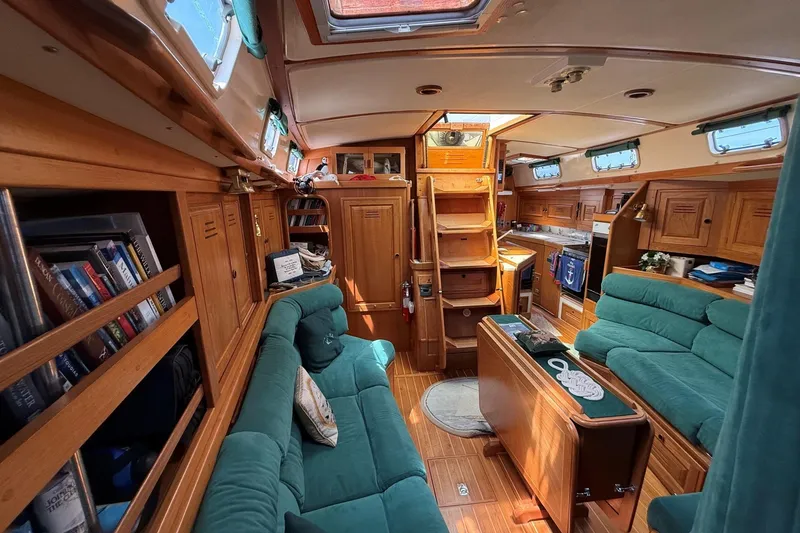 Slide: The Image of Interior of a 1993 Tartan 4600 sailboat with wooden furnishings and teal seating. - 29