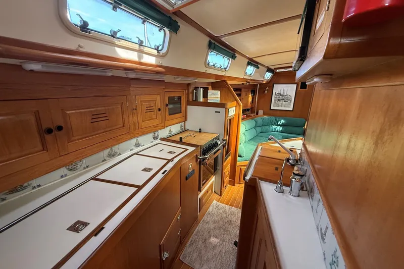 Slide: The Image of Interior of a 1993 Tartan 4600 sailboat featuring a cozy kitchen and seating area. - 26