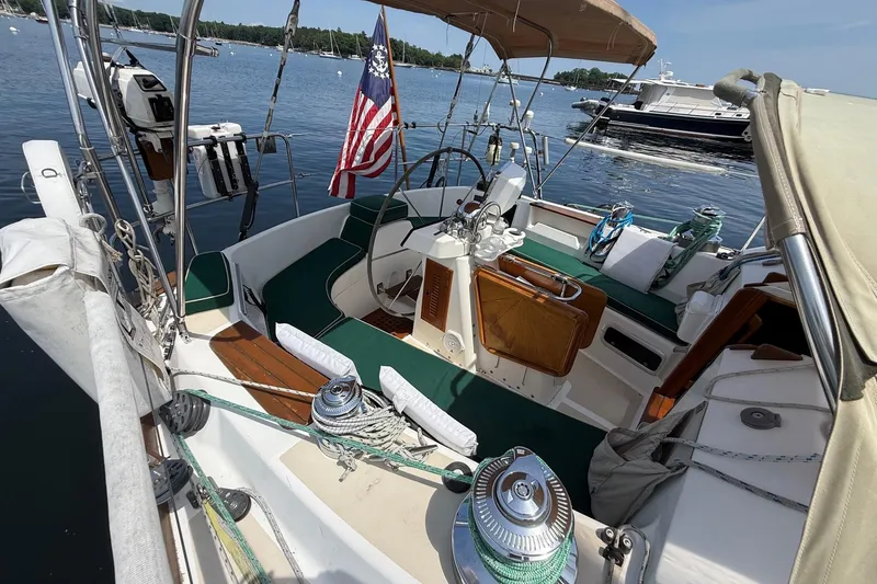 Slide: The Image of Sailboat Tartan 4600 from 1993 docked, featuring a spacious cockpit and American flag. - 10