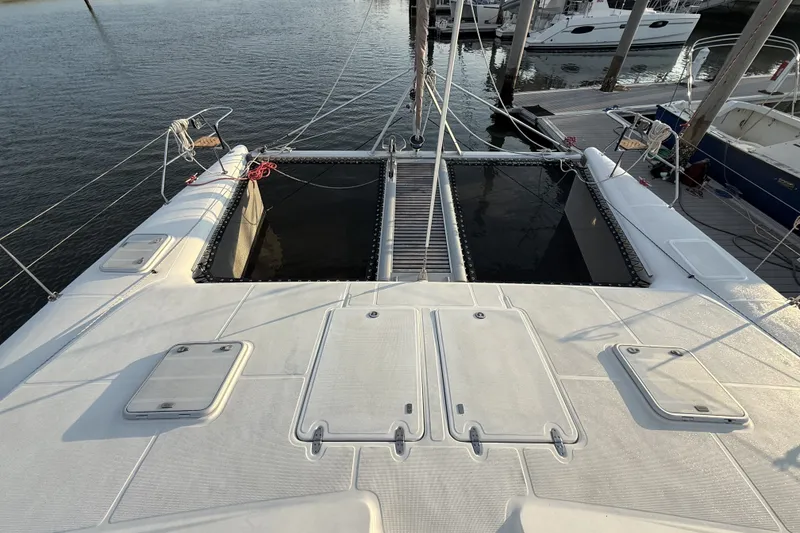 Slide: The Image of Deck view of a 2002 Voyage 440 catamaran docked at a marina. - 10
