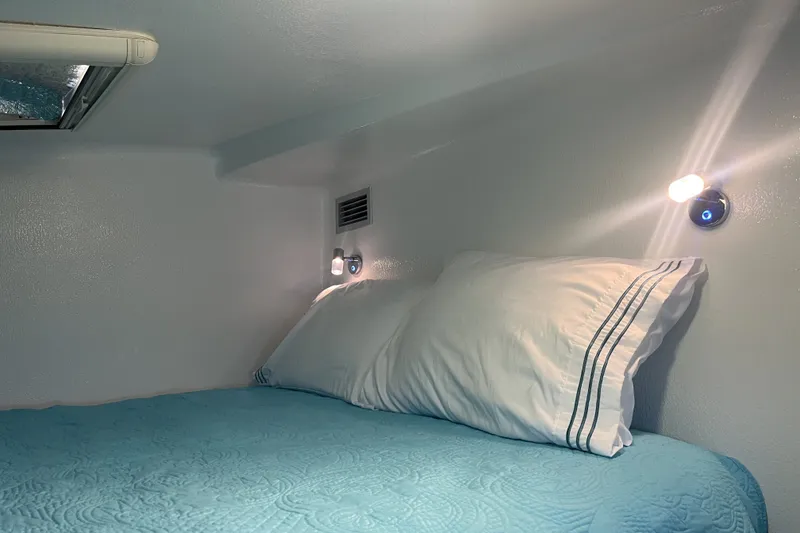 Slide: The Image of Cozy cabin interior of 2002 Voyage 440 with blue bedding and soft lighting. - 26