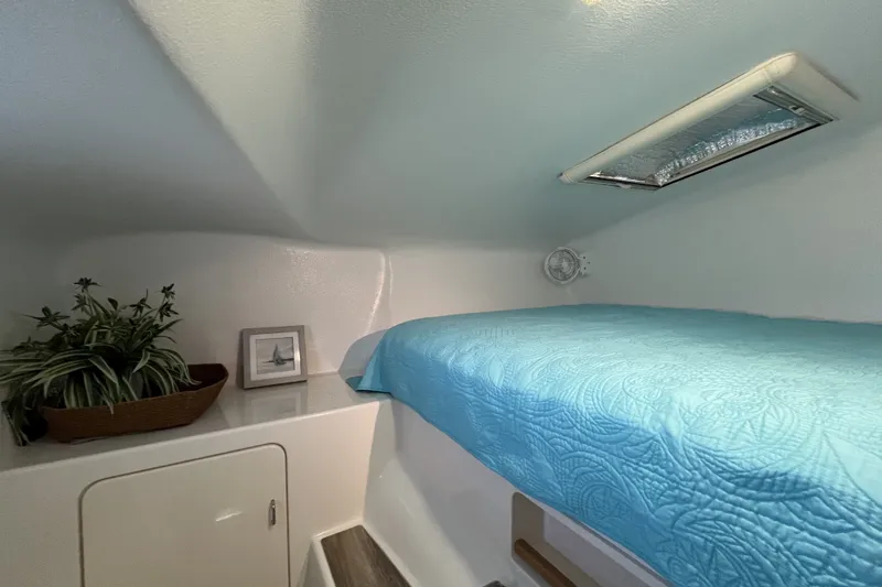 Slide: The Image of Cozy cabin interior of 2002 Voyage 440 yacht with blue bedding and porthole. - 27