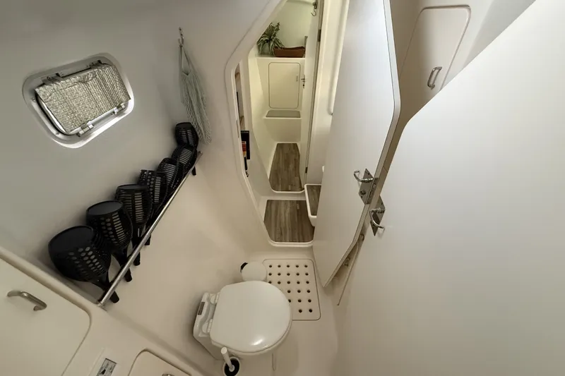 Slide: The Image of Compact bathroom in a 2002 Voyage 440 yacht, featuring a toilet and storage. - 25