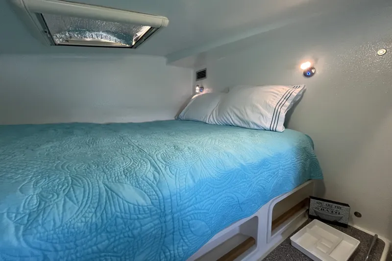 Slide: The Image of Cozy cabin interior of 2002 Voyage 440 with blue bedding and soft lighting. - 28