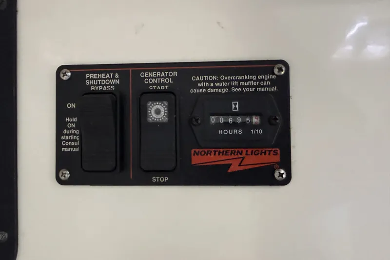 Slide: The Image of Voyage 440 2002 generator control panel with hour meter and caution label. - 43