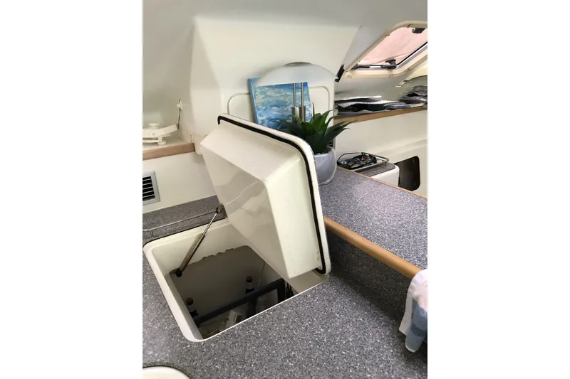 Slide: The Image of Interior of a 2002 Voyage 440 yacht with open storage compartment and countertop. - 19
