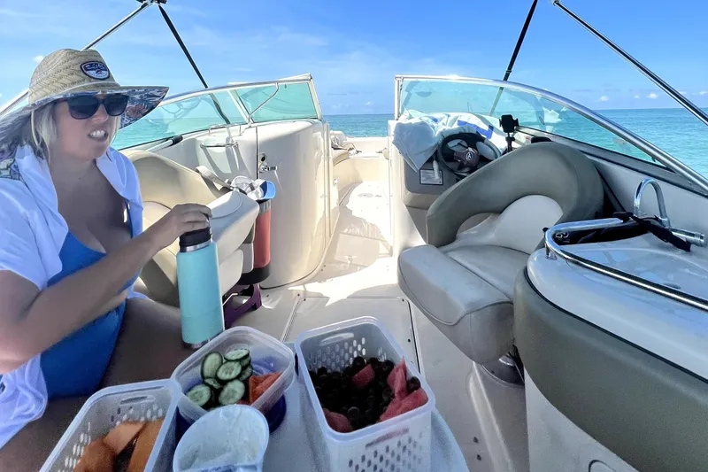Slide: The Image of Woman enjoying snacks on a 2005 Sea Ray 240 Sundeck boat, ocean backdrop. - 7