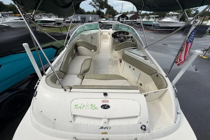 Slide: The Image of 2005 Sea Ray 240 Sundeck boat with spacious seating and American flag. - 11