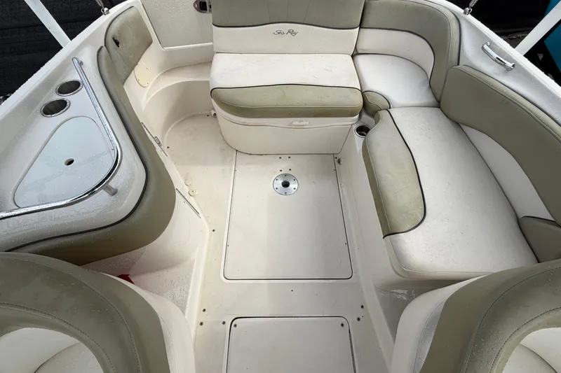 Slide: The Image of 2005 Sea Ray 240 Sundeck interior with beige seating and cup holders. - 23