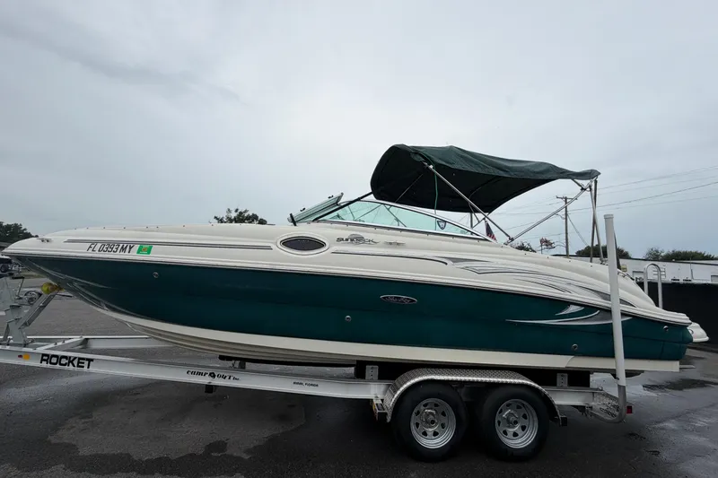 Slide: The Image of 2005 Sea Ray 240 Sundeck boat on trailer, featuring green hull and canopy. - 8