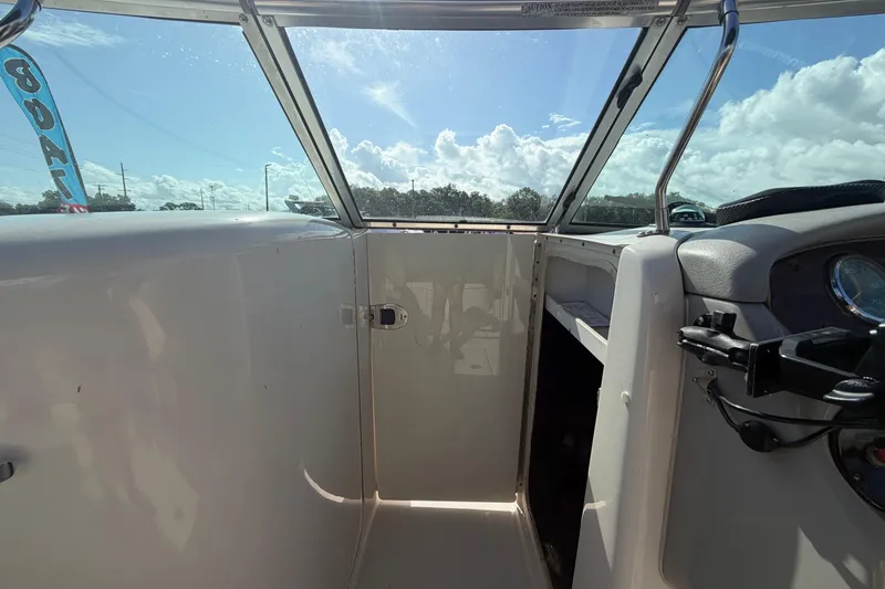 Slide: The Image of 2005 Sea Ray 240 Sundeck interior view with clear skies and dashboard details. - 42