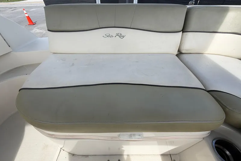 Slide: The Image of 2005 Sea Ray 240 Sundeck boat seating with beige upholstery and logo. - 71